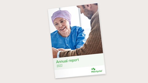 Portada del Informe Anual 2022 integrado de Mölnlycke con una profesional sanitaria hablando con un hombre.