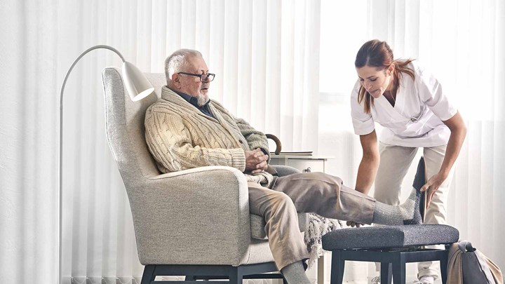 Un profesional sanitario ayudando a un anciano